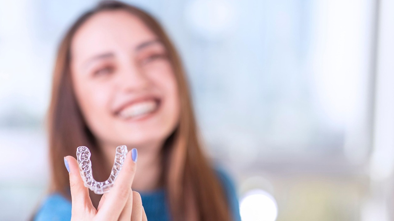 Jeune femme tenant une gouttière dentaire invisible en main