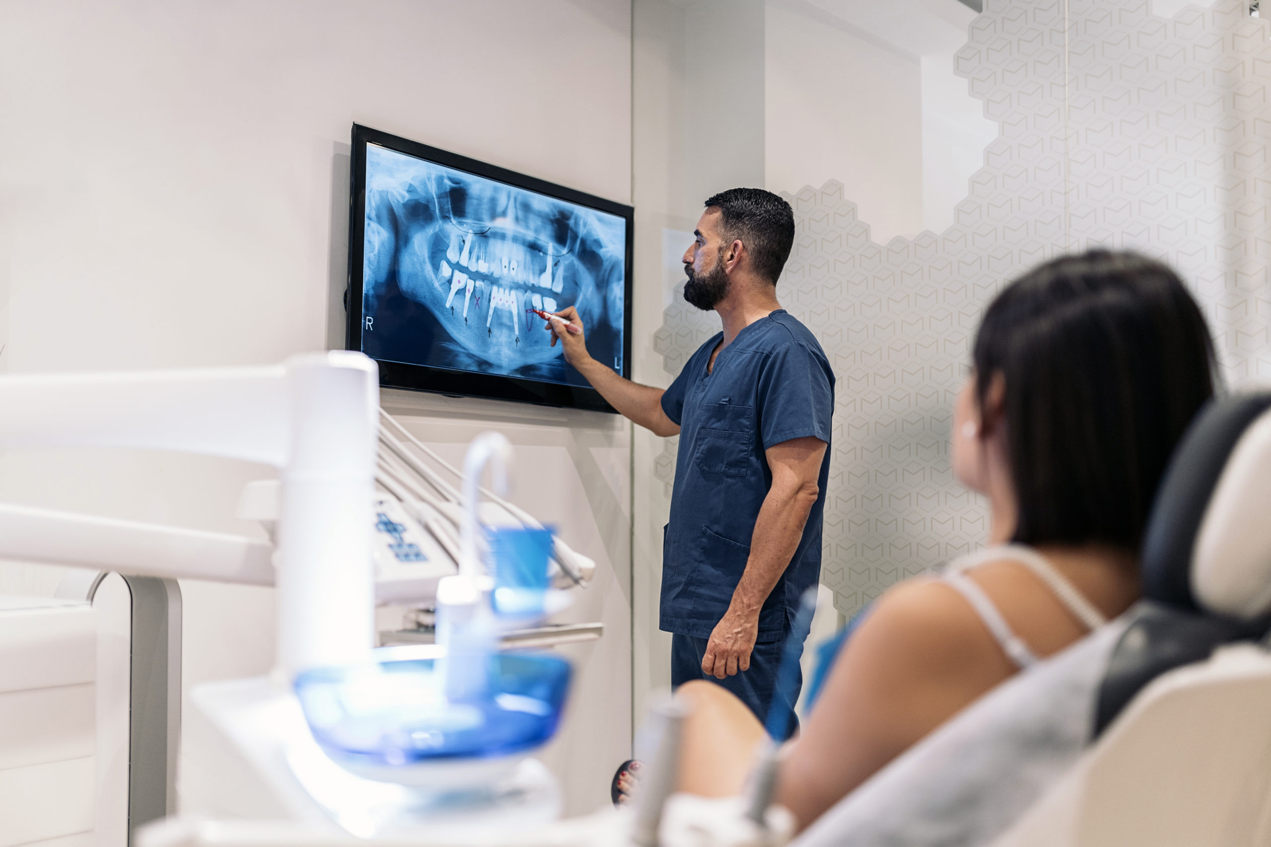 Dentiste présentant une radiographie dentaire numérique à une patiente chez Urbadental